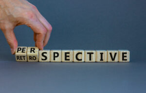 Fingers moving letter tiles showing Perspective and Retrospective